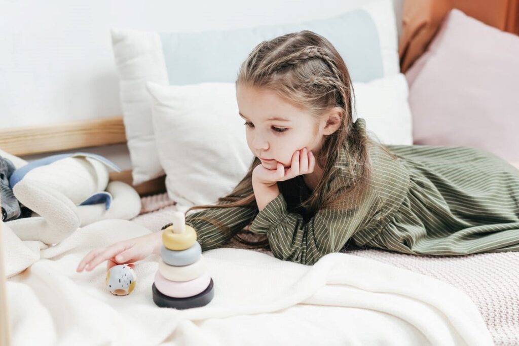 A kid playing with their toys on the bed